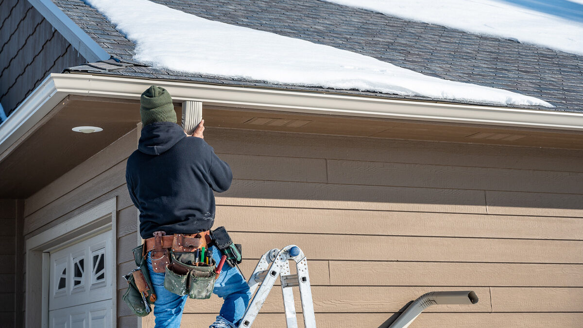 Man Repairing Roof In The Snow In Wichita Ks